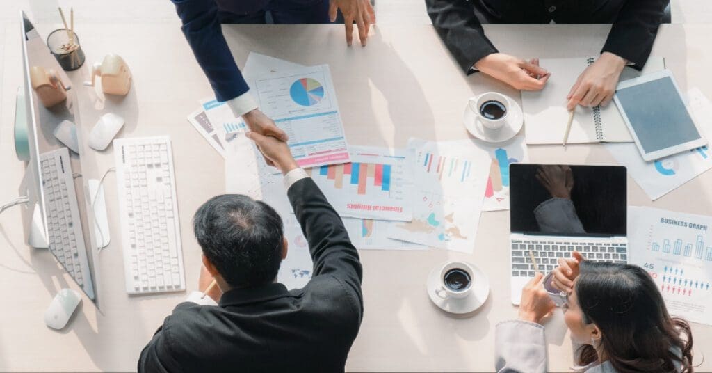 empresarios-apertando-as-maos-depois-de-fechar-negocio-no-escritorio-shutterstock