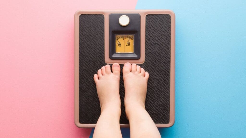 pes-descalcos-de-uma-crianca-em-cima-de-uma-balanca-para-controle-do-peso-obesidade-infantil