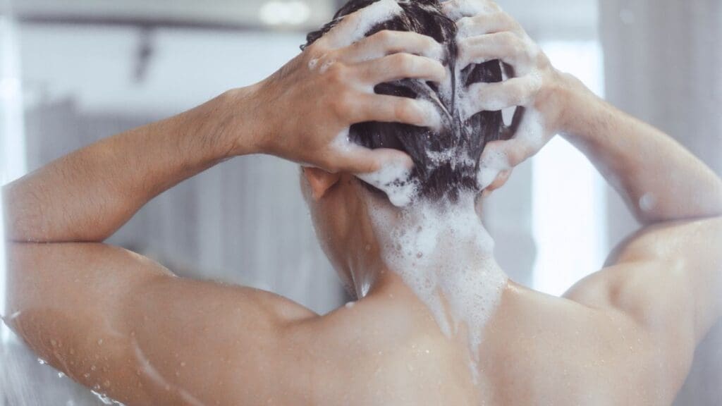 homem-branco-jovem-lavando-cabelo-no-chuveiro-shutterstock