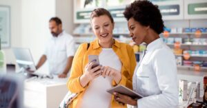 consumidora-gravida-conversando-com- farmaceutica-na-farmacia